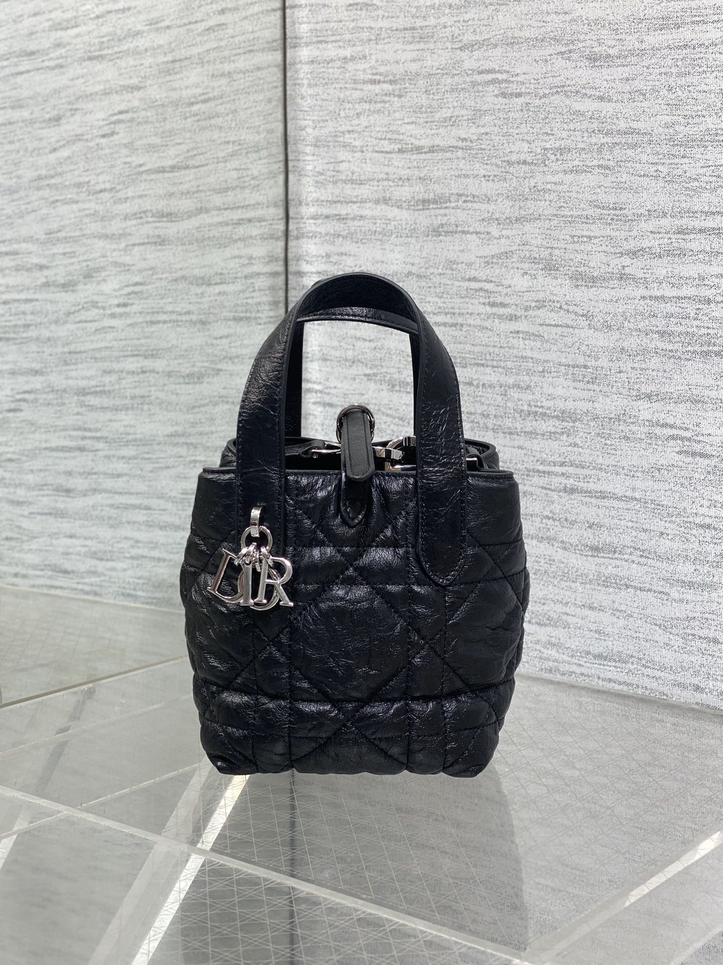 Black quilted mini handbag with top handle and front clasp