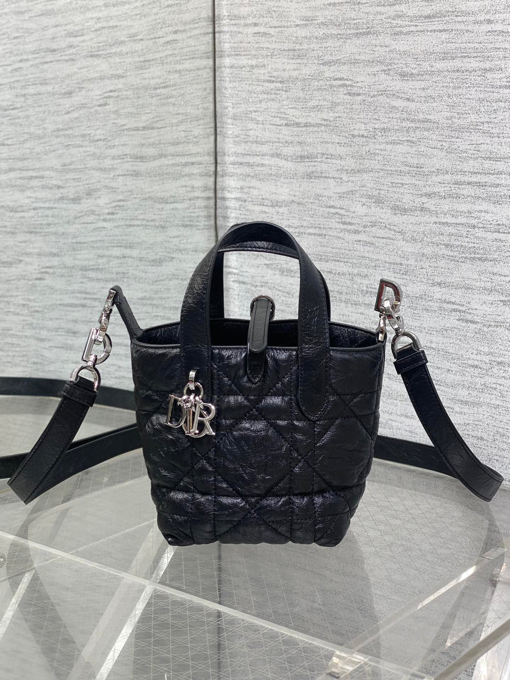 Black quilted mini handbag with two shoulder straps and front clasp