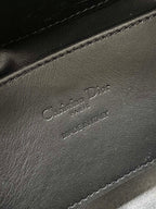 Black leather Dior-embossed handbag detail with stitched edge