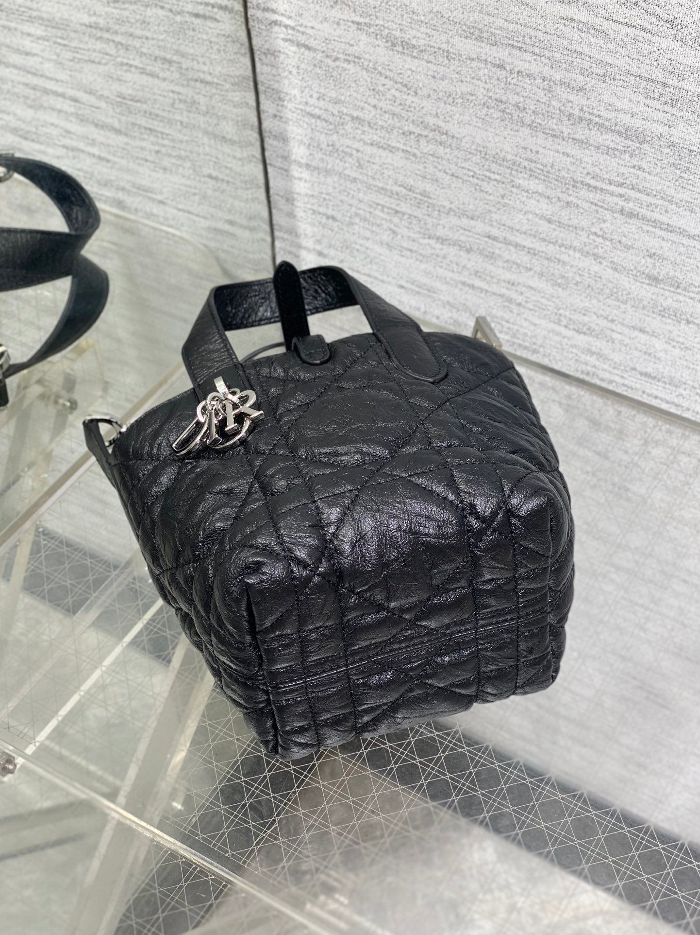 Black quilted mini handbag open top showing interior and shoulder strap