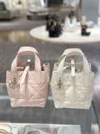 Dior bag pair of quilted mini totes in blush pink and white with logo charm and handles
