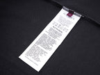 Black T-shirt with white size label near inner neck