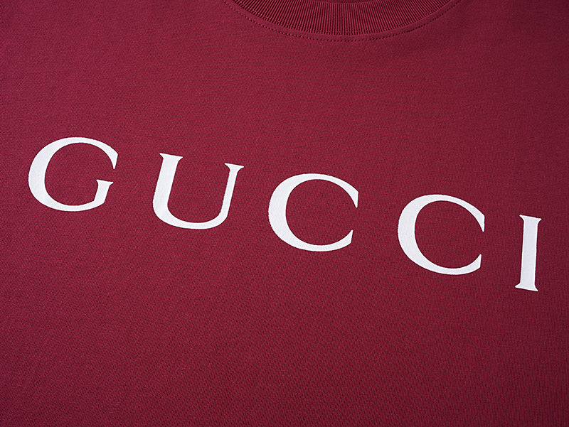 Burgundy Gucci T-shirt front with partial white GUCCI lettering