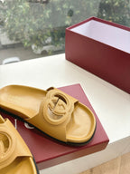 Gold Gucci slide sandals close-up of interlocking G strap and footbed
