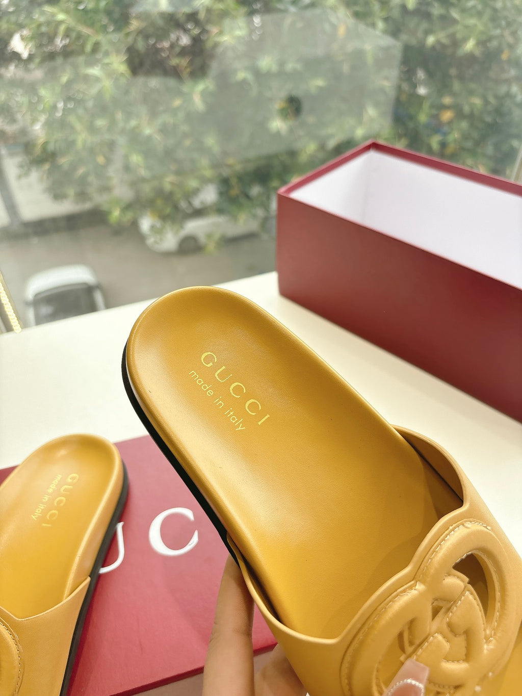 Gold Gucci slide sandals close-up of insole text and interlocking G logo
