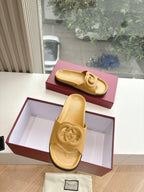 Gold Gucci slide sandals with interlocking G strap, heel-on view