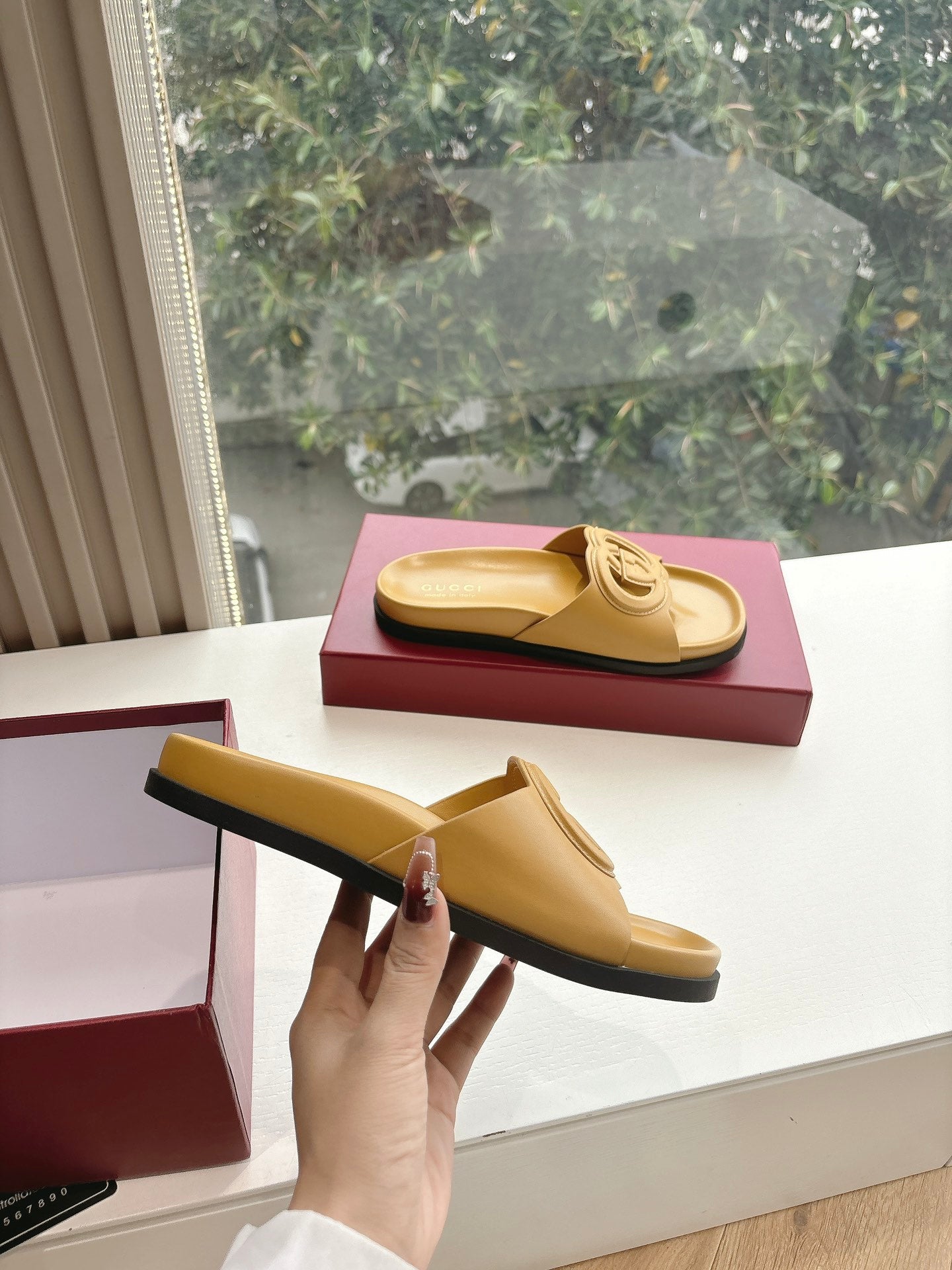 Gold Gucci slide sandals, side view with interlocking G emblem