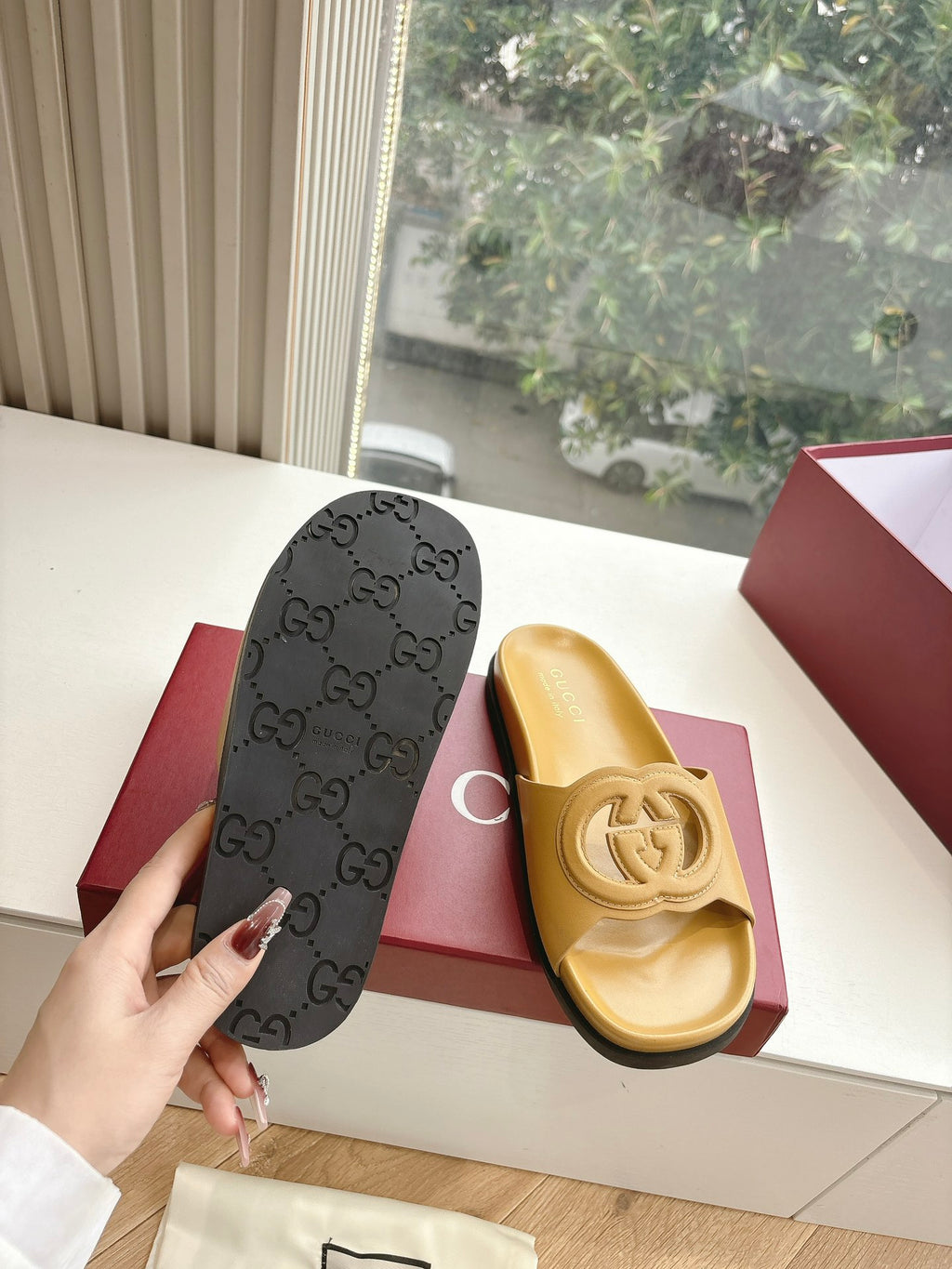 Gold Gucci slide sandals with black Gucci monogram dust bag