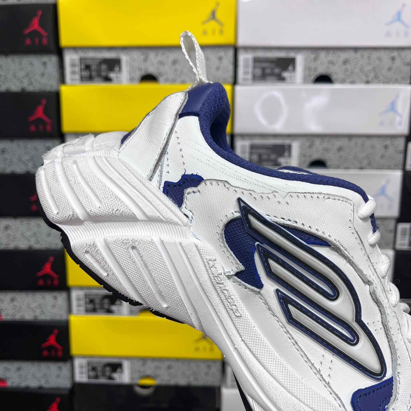 White and blue lace-up sneaker, front-quarter view, chunky ridged sole
