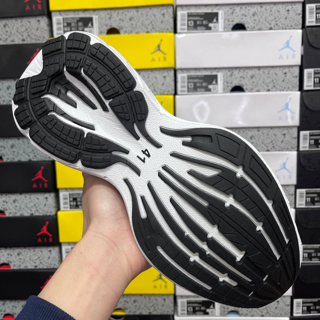 Black and white rubber outsole with tread pattern under sneaker