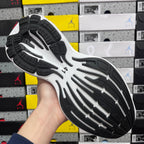 Black and white rubber outsole with tread pattern under sneaker