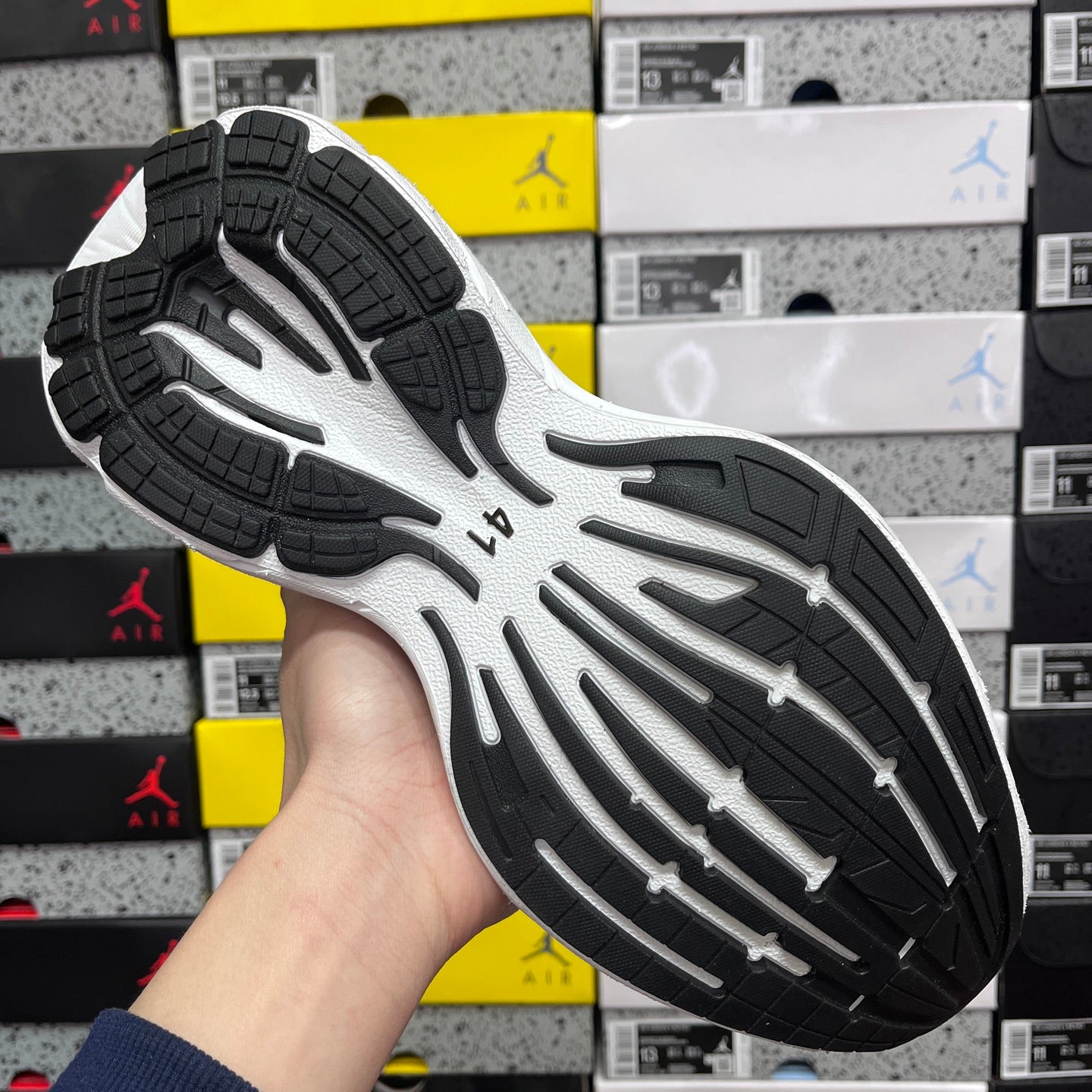 Black and white rubber outsole with tread pattern under sneaker