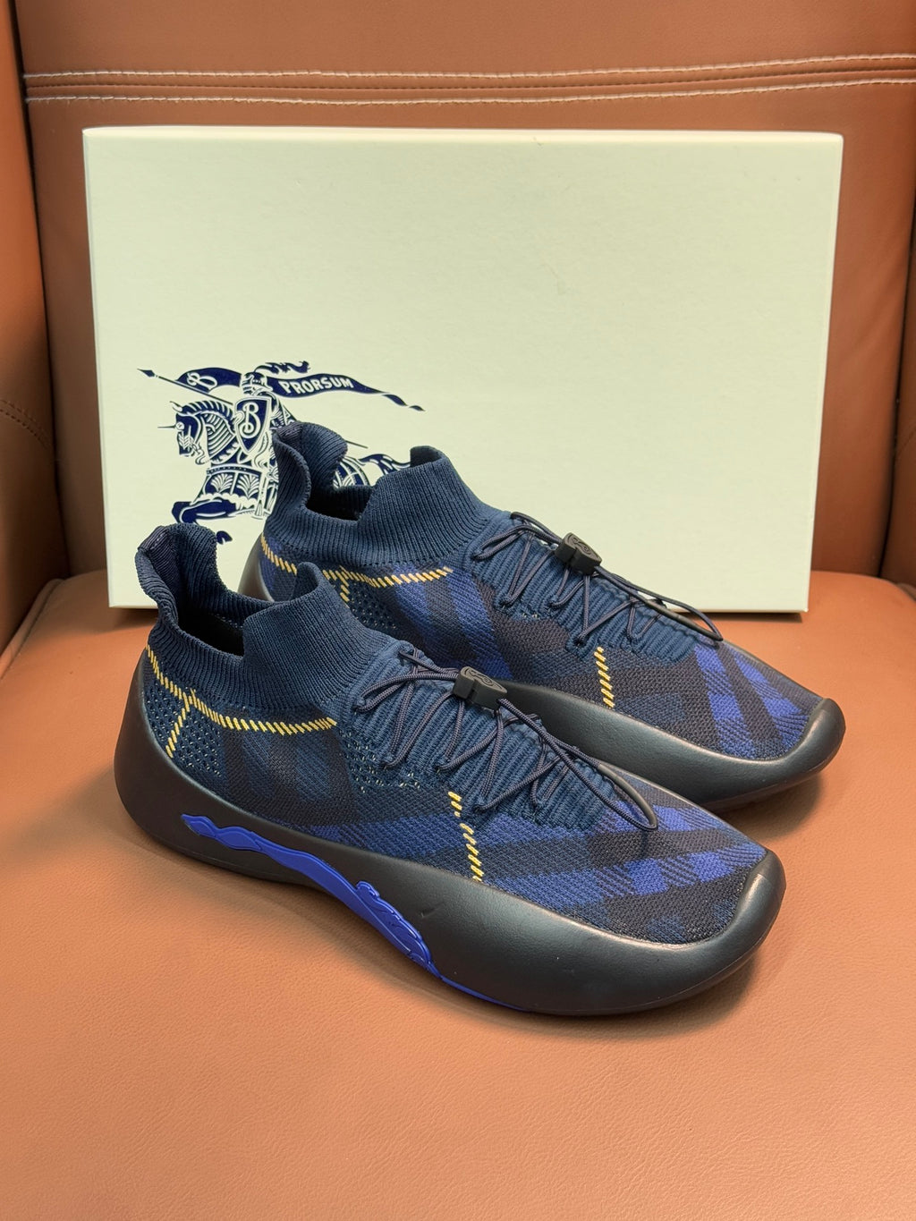 Burberry blue knit sneakers with black sole and yellow cross-hatch stitching