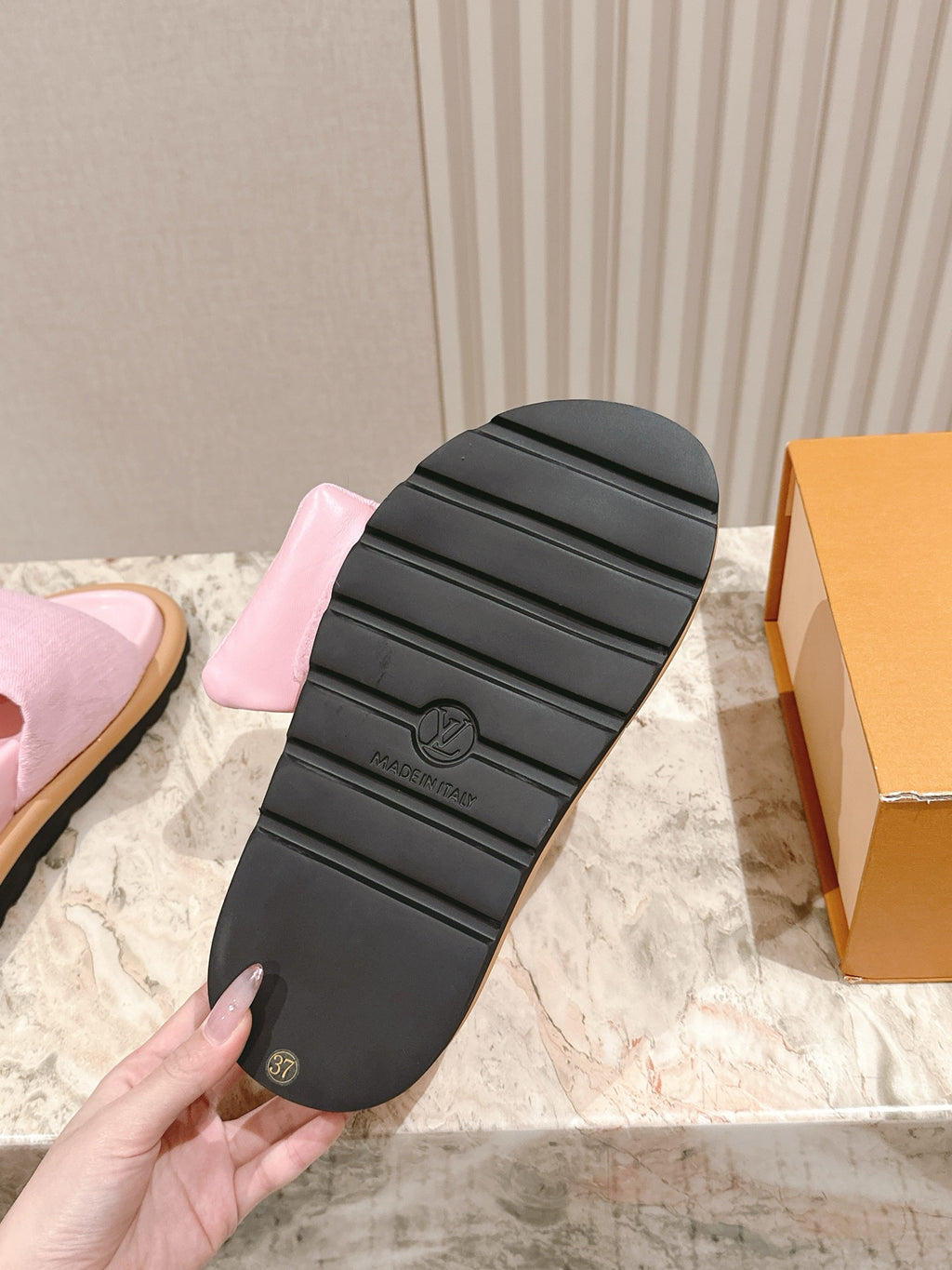Louis Vuitton slide sandals with black tread sole underside, tan edge and pink upper