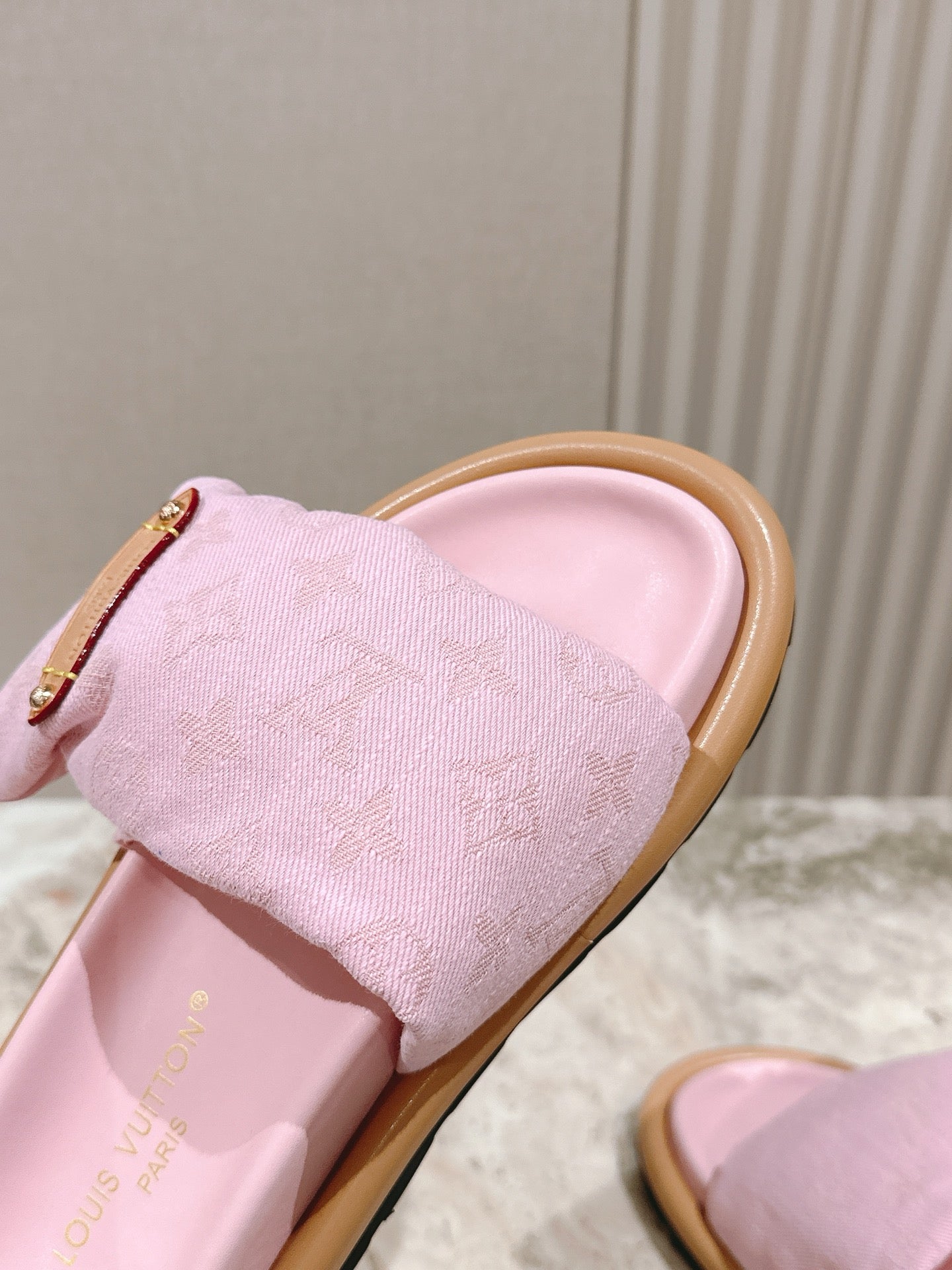 Louis Vuitton pink fabric slide sandal close-up on strap, gold-tone metal buckle