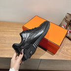Black sneaker showing thick tread sole and lace-up upper, Hermes unisex