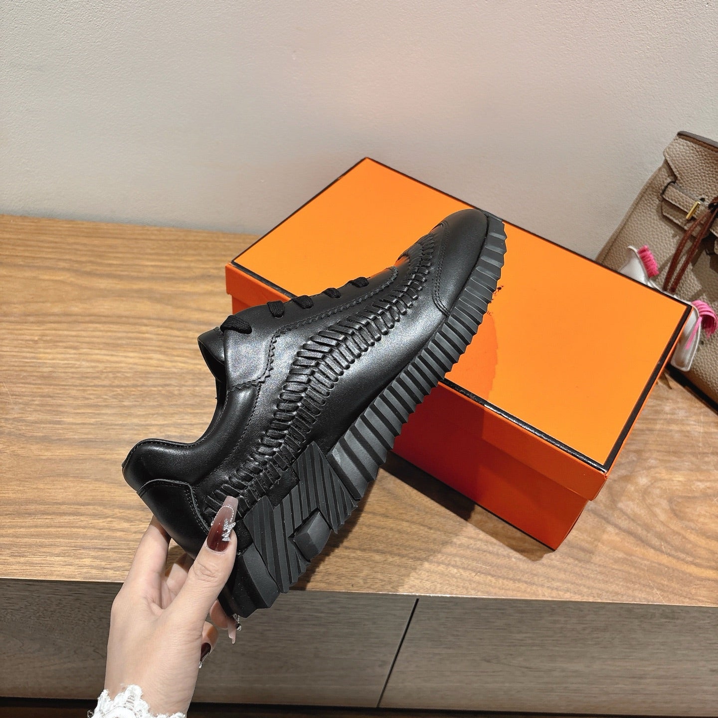 Black sneaker showing thick tread sole and lace-up upper, Hermes unisex