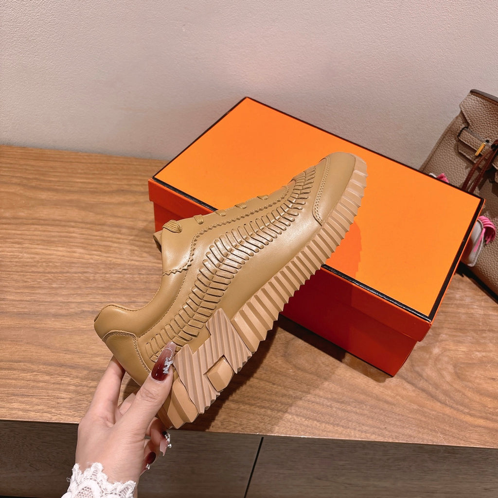 Beige lace-up sneaker on display with ridged outsole and textured side paneling