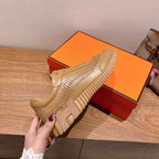 Beige lace-up sneaker on display with ridged outsole and textured side paneling