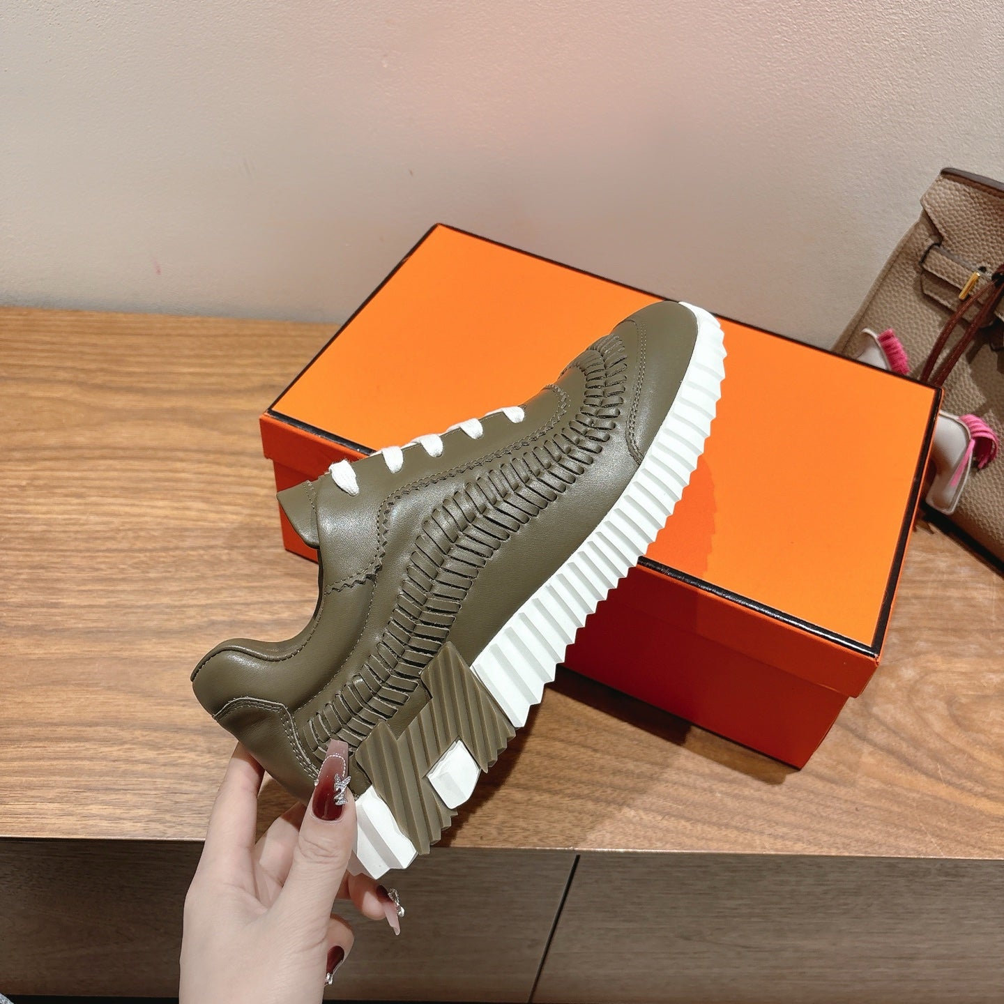 Hermes unisex luxury sneaker in olive green with white laces and thick white ridged sole