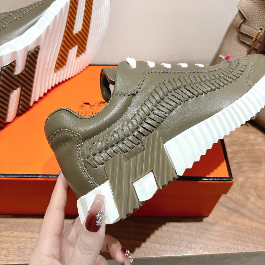 Hermes unisex luxury sneaker in olive green with white laces and ribbed tread sole