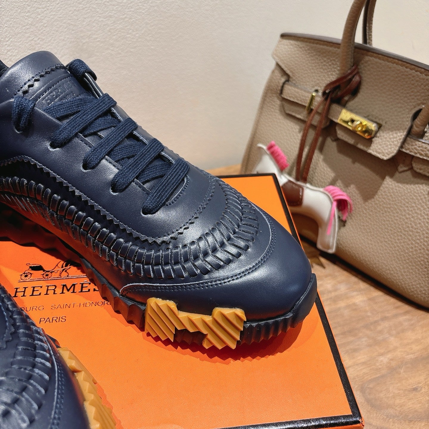 Hermes unisex sneaker close-up in dark blue, lace-up vamp with ridged rubber sole