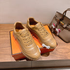 Beige lace-up sneakers with white sole trim and layered, ridged outsole