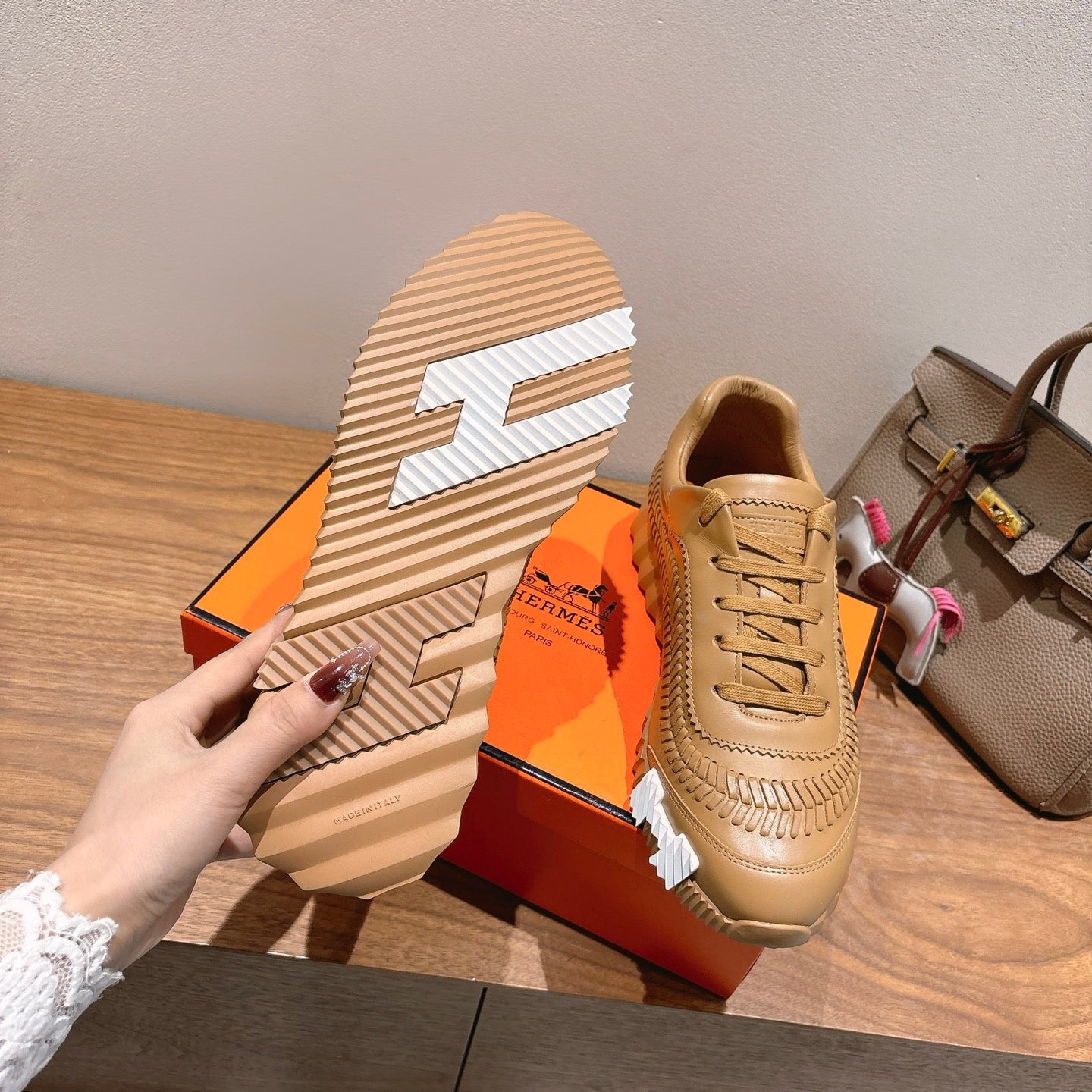 Beige lace-up sneaker with patterned outsole and decorative stitched side panels