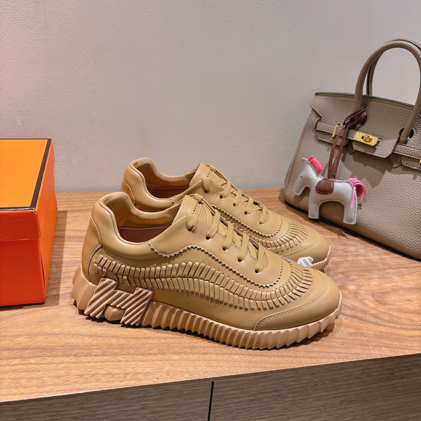 Beige low-top lace-up sneakers with ribbed sole and perforated side stitching