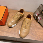 Beige lace-up sneakers with textured panels, stitched details, and chunky tread