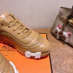 Beige lace-up sneaker close-up with stitched edge trim and chunky tread