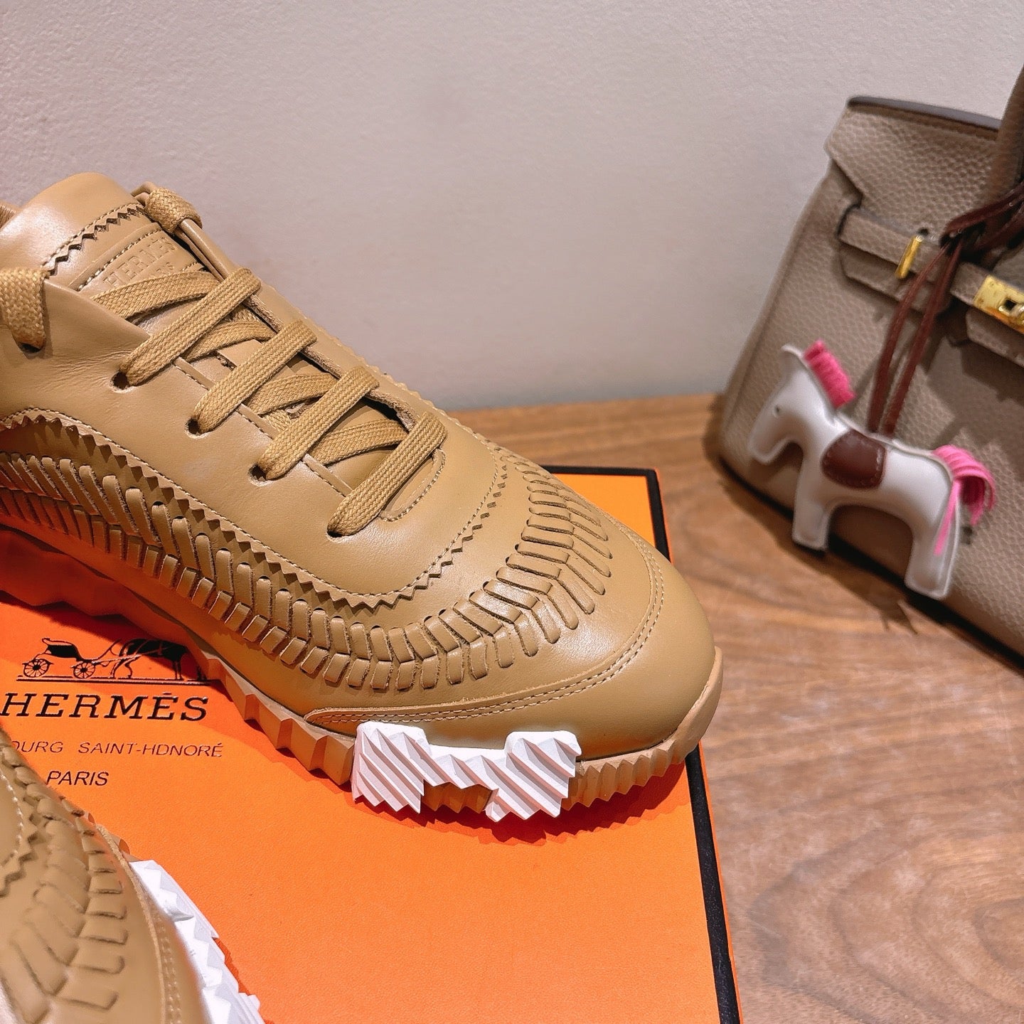 Beige lace-up sneaker close-up with stitched edge trim and chunky tread