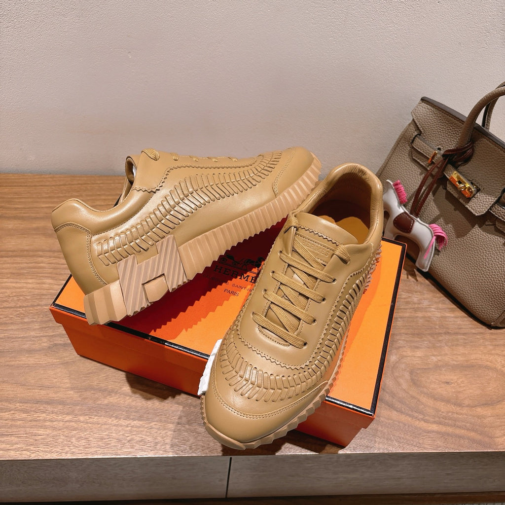 Beige sneaker with lace-up front, raised seam detailing, and thick striped sole