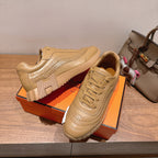 Beige sneaker with lace-up front, raised seam detailing, and thick striped sole
