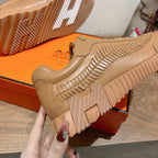 Beige sneaker close-up with ribbed lugs on the outsole and side texture stitching