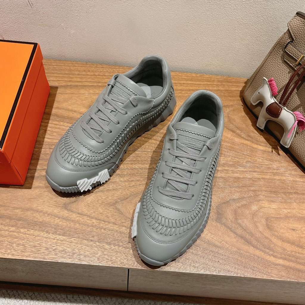 Pair of gray lace-up sneakers with ribbed side texture and thick white sole.