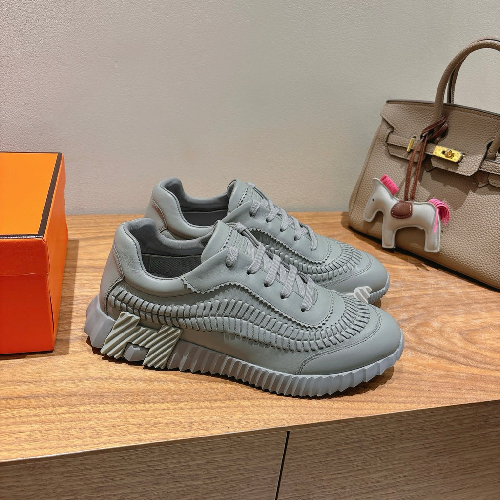 Gray lace-up chunky sneakers with sculpted side stitching and ridged sole.