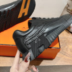 Black sneaker close-up of treaded sidewall and chunky outsole, Hermes unisex