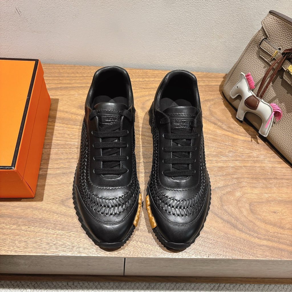 Black lace-up Hermes unisex sneakers with textured panels and chunky rubber sole