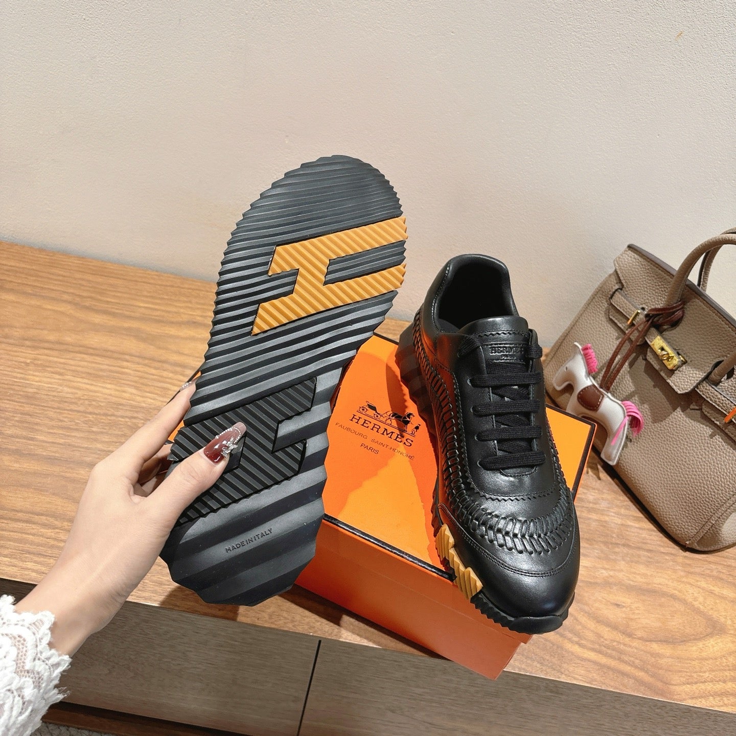 Black lace-up sneaker outsole with yellow stripe pattern, Hermes unisex