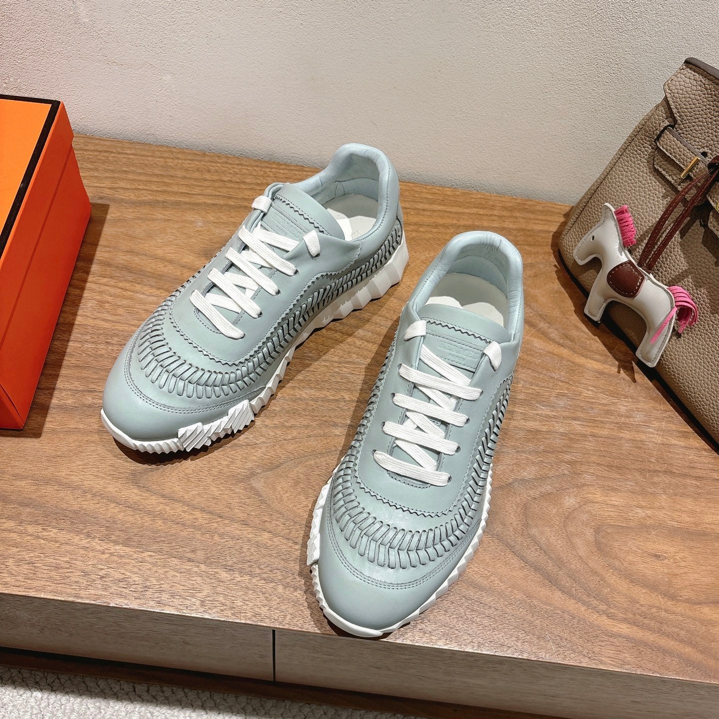 Hermes unisex light blue sneakers, side and front view with white lace-up