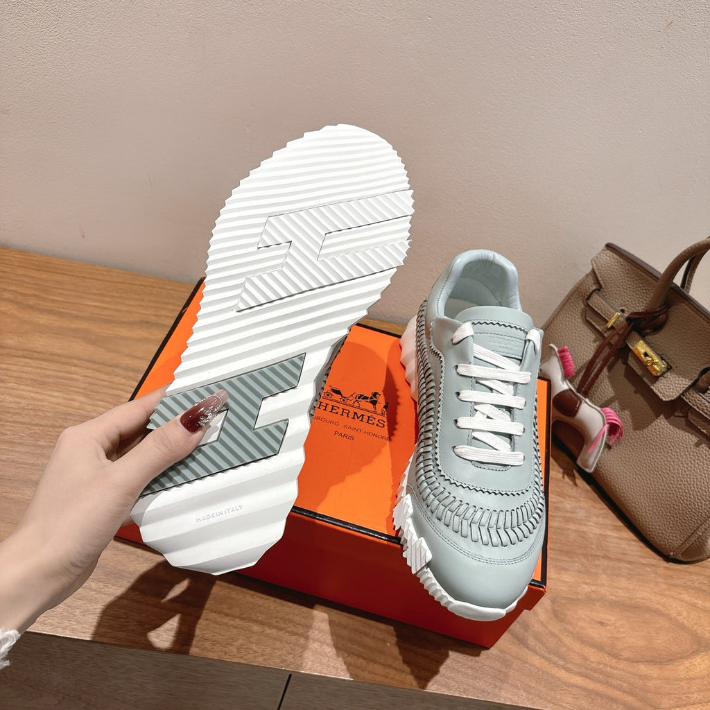 Hermes unisex sneaker outsole and heel with textured tread and light blue upper