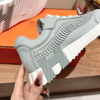 Hermes unisex light blue sneaker with white laces and sculpted side panels