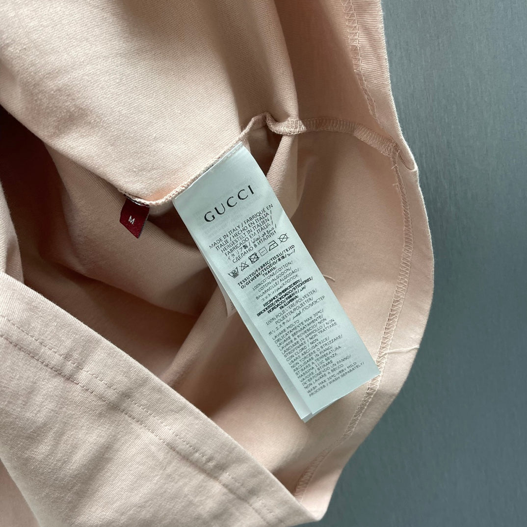Light pink T-shirt with care label tag near collar
