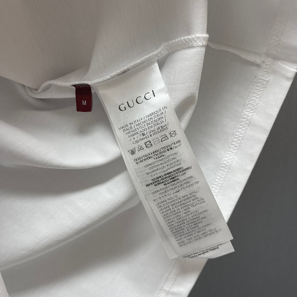 White T-shirt fabric with Gucci size tag and care label near collar