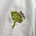 Close-up of green rose and red Gucci embroidery on white T-shirt