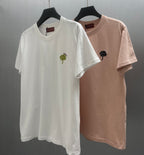 Two short-sleeve T-shirts: white with green rose and blush pink with black flower