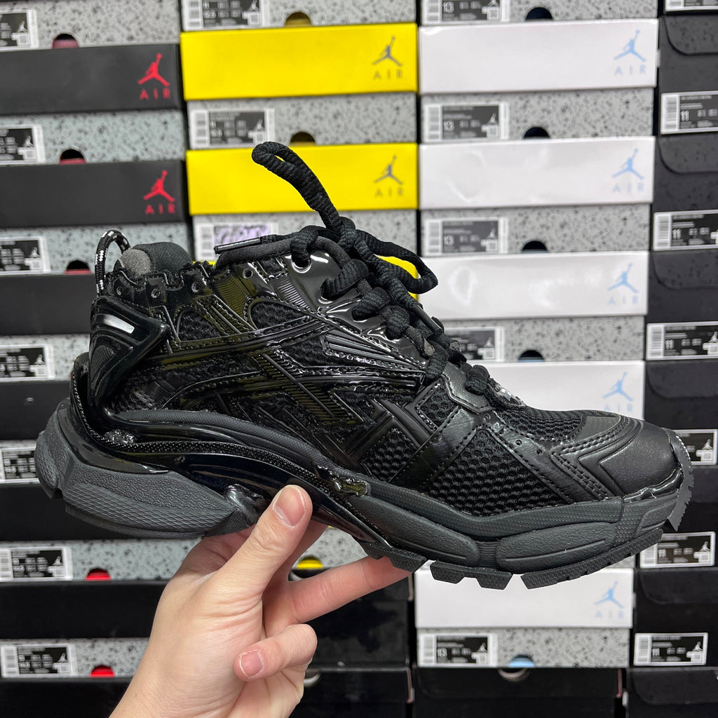 Balenciaga unisex black running sneaker angled side view with lace-up closure