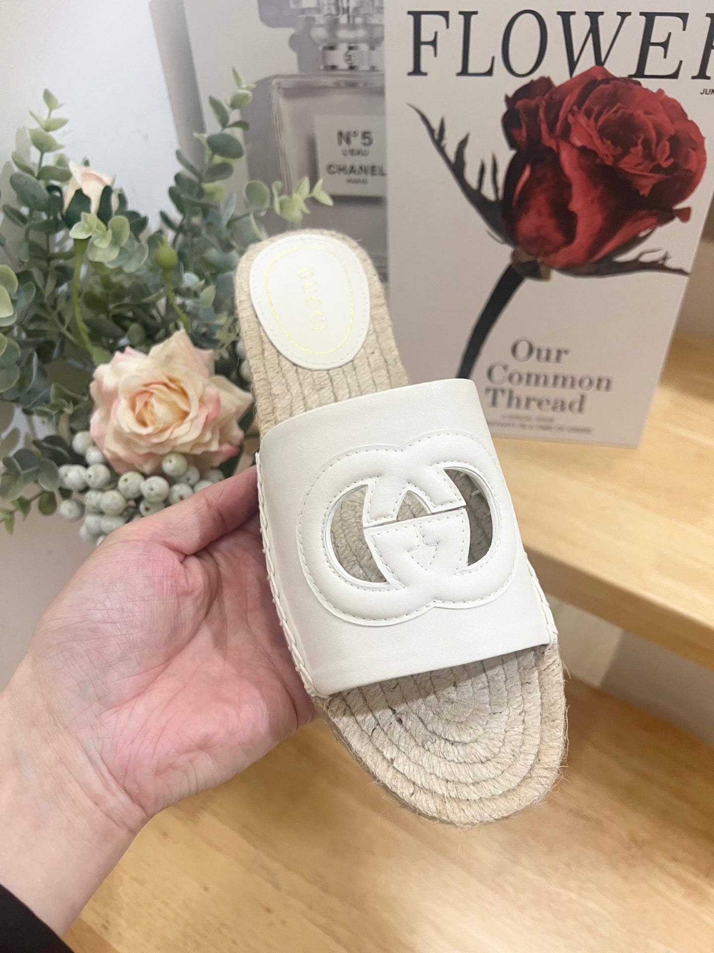 Gucci white slide sandal heel view with logo strap and woven jute espadrille sole.