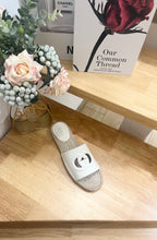 Single white slide sandal with black logo cutout and textured jute sole
